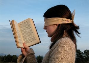 Girl reading a spanish novel while blindfolded