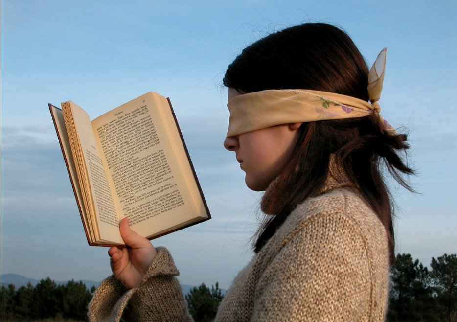 Blindfolded girl reading a spanish novel